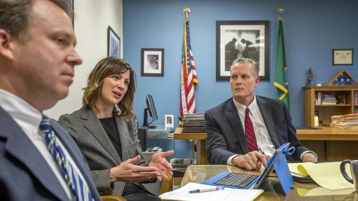 Deputy prosecutor Erika Nohavec talks March 11 about her years of specializing in elder abuse cases as Sven Nelson, left, and Pierce County Prosecutor Mark Lindquist listen. She is turning over those duties to Nelson this week.