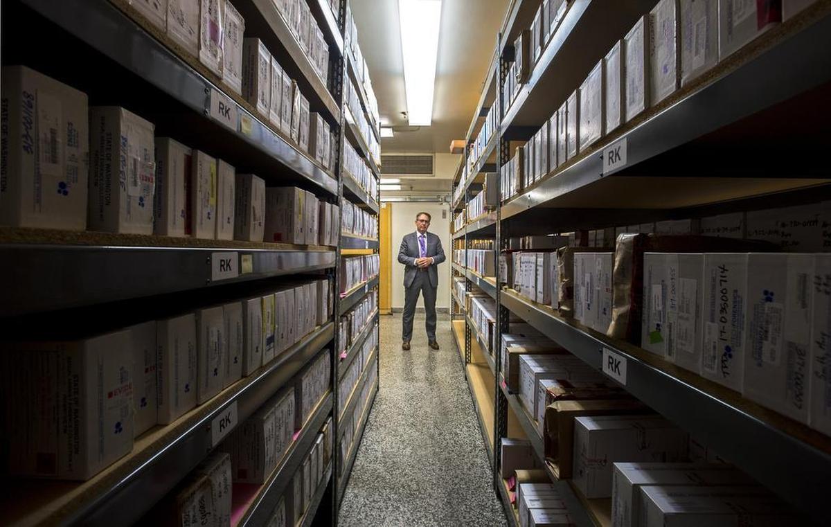 Tacoma Police Det. Bradley Graham of the department's Special Assaults Unit stands among shelves of "rape kits", some of which have never been tested for lack of resources.