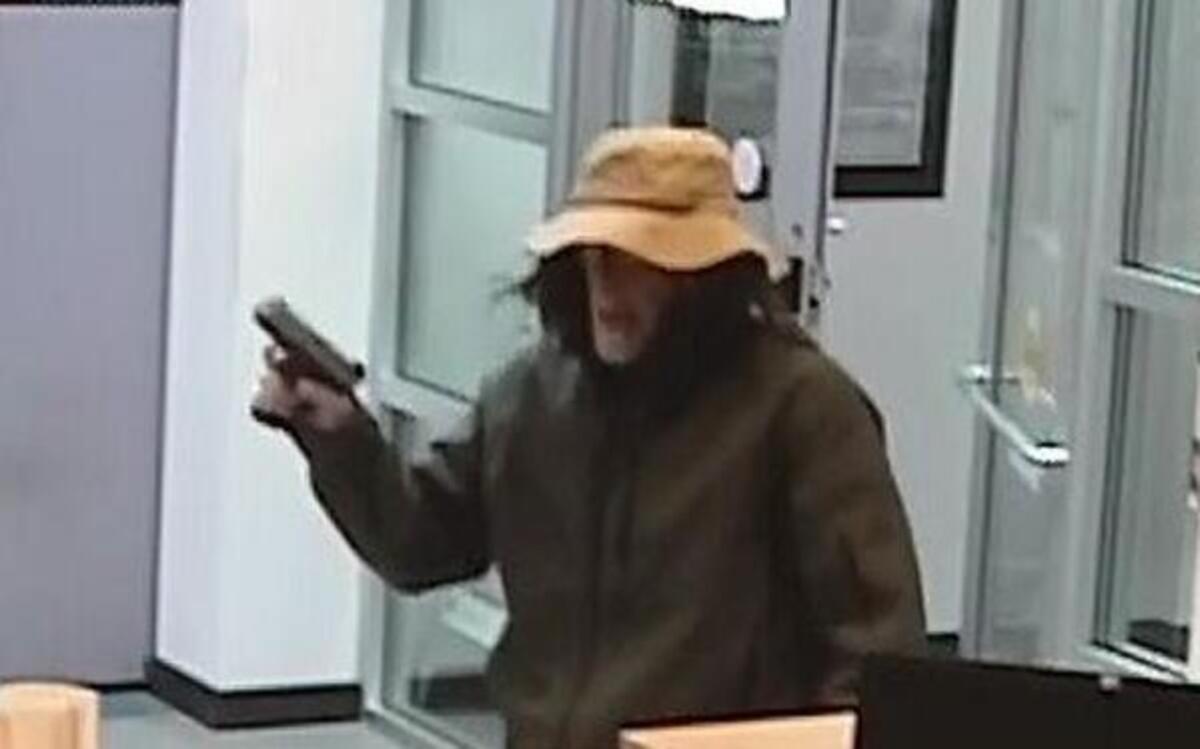 An unidentified man brandishes a gun during a Monday morning robbery of the U.S. Bank branch on Puyallup’s South Hill.