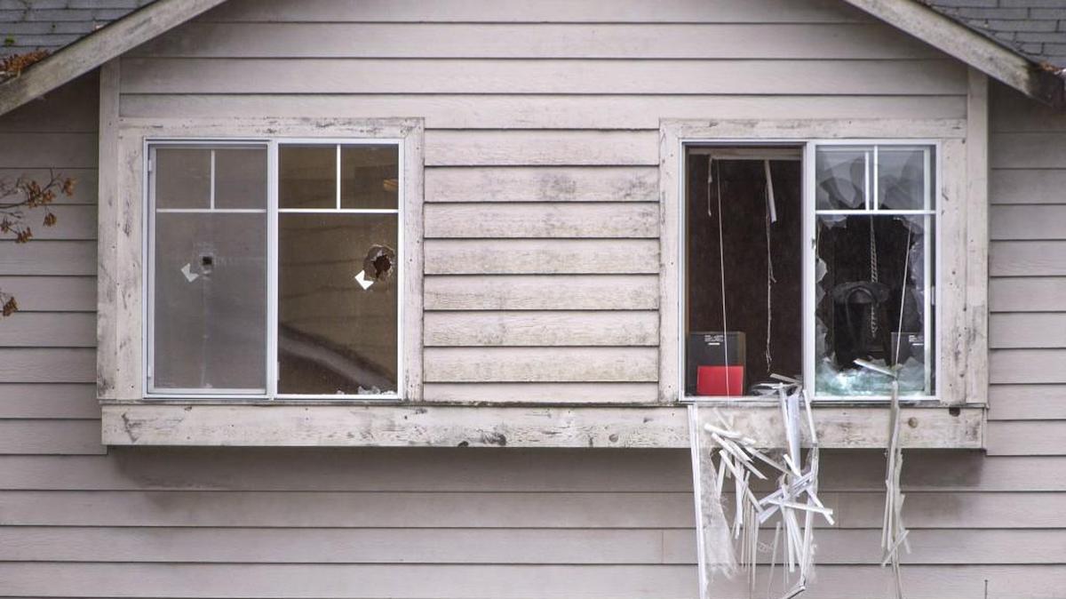 Bullet holes can be seen in the windows of this home on East 52nd Street in Tacoma where Tacoma police officer Reginald “Jake” Gutierrez was killed responding to a domestic violence call. His assailant, Bruce Johnson II, was shot dead by police after barricading himself in one of the upstairs bedrooms with two of his children.