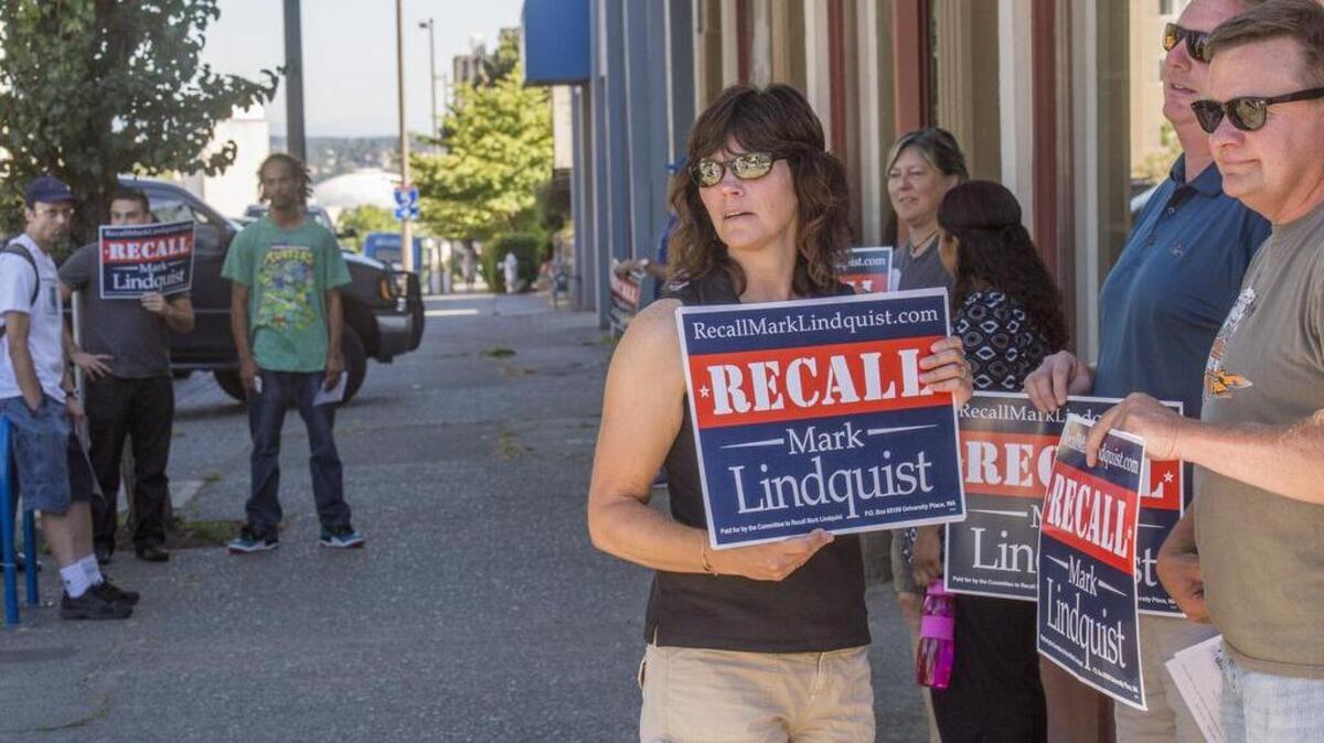 
Demonstrators wanting to recall Pierce County Prosecutor Mark Lindquist hold signs outside of a Lindquist fundraiser Thursday at King’s Books in Tacoma.
