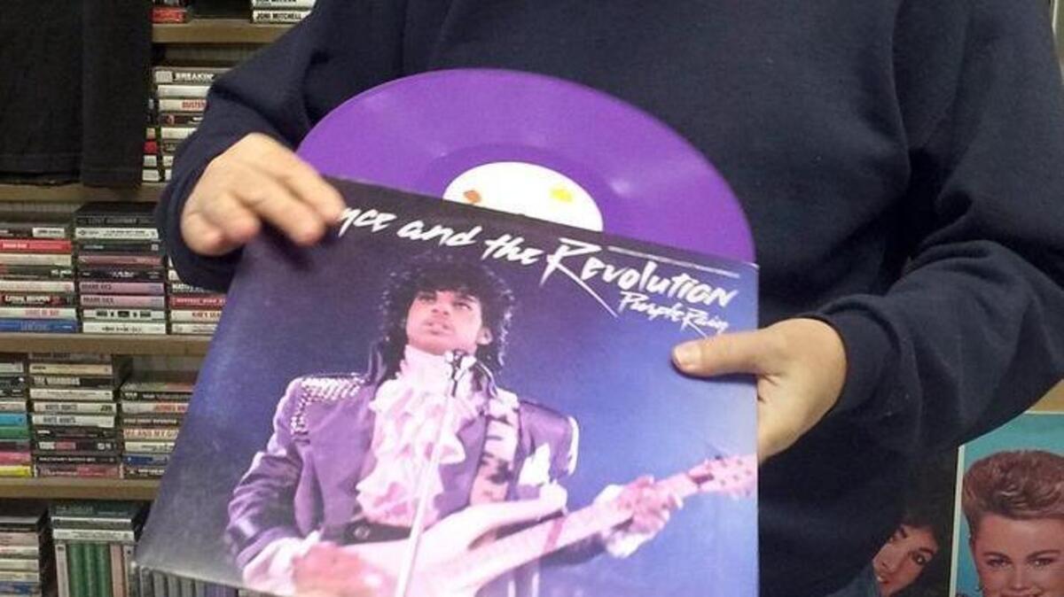 Charles Rice, owner of Tacoma’s Drastic Plastic, looks over a rare purple vinyl single of Prince’s “Purple Rain” on Thursday morning.