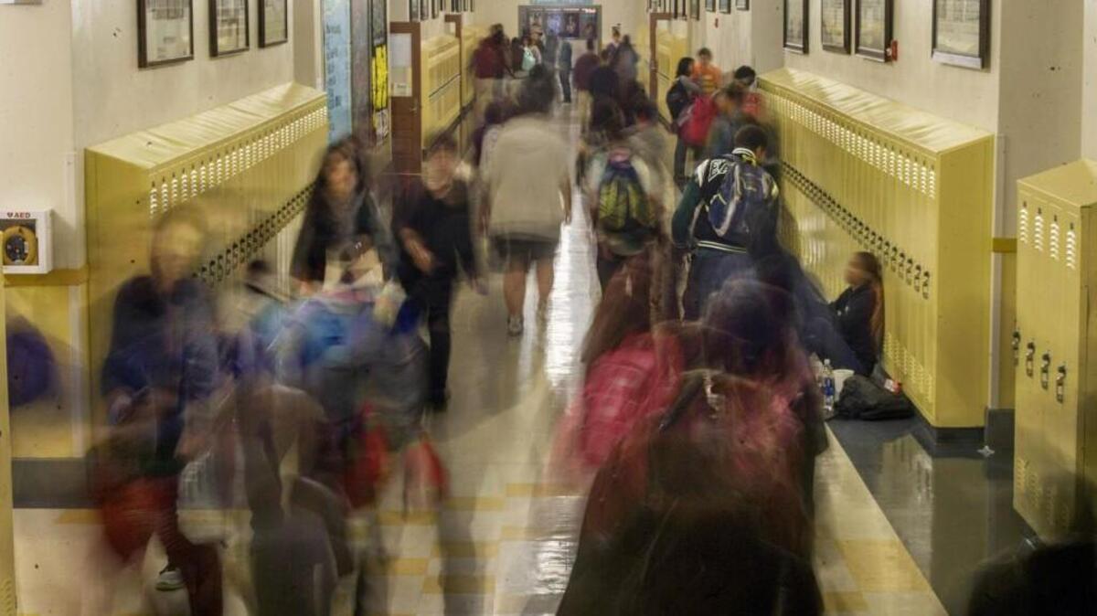 In a photograph shot with a slow shutter speed, students are shown traveling a hallway at Lincoln High School in Tacoma on Dec. 2.