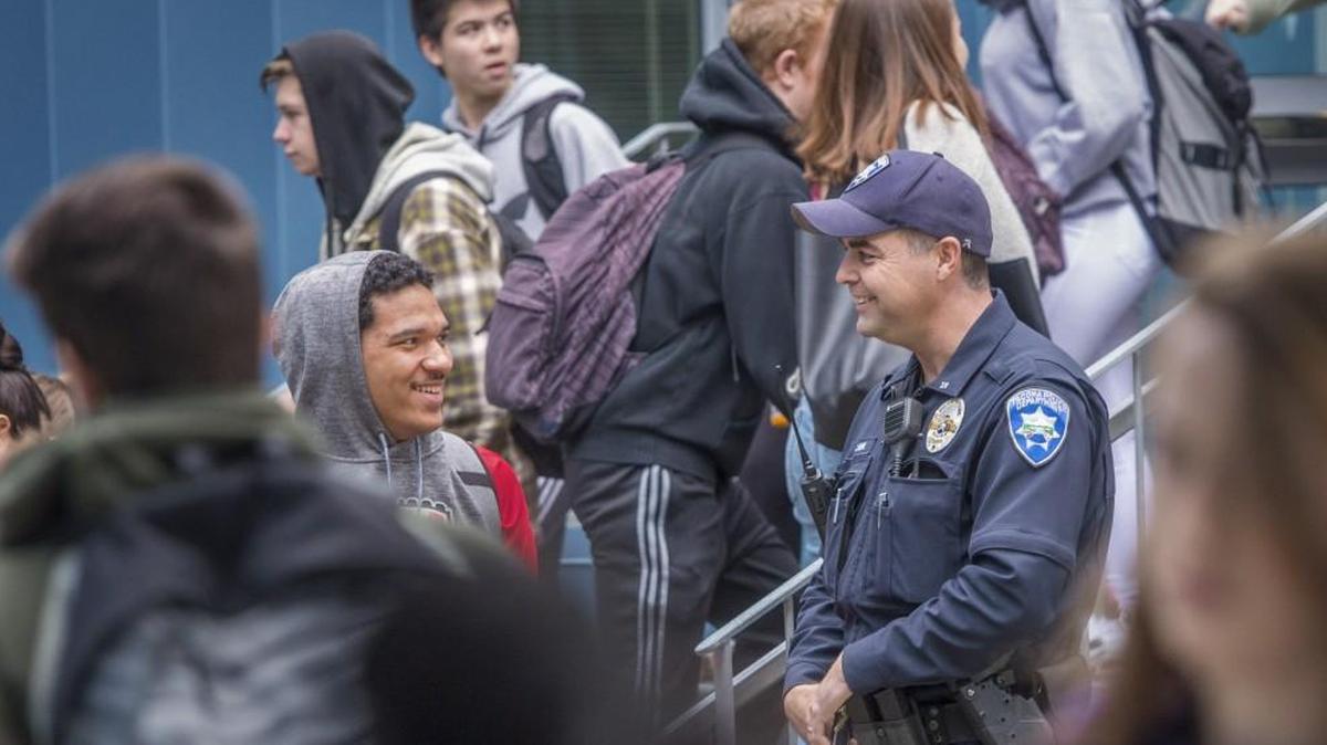 Tacoma Police officer Keith Miner chats with Tyrique Bell during pass time at Wilson High School, January 31, 2018. Resource officers such as Miner are funded by the local school levy.