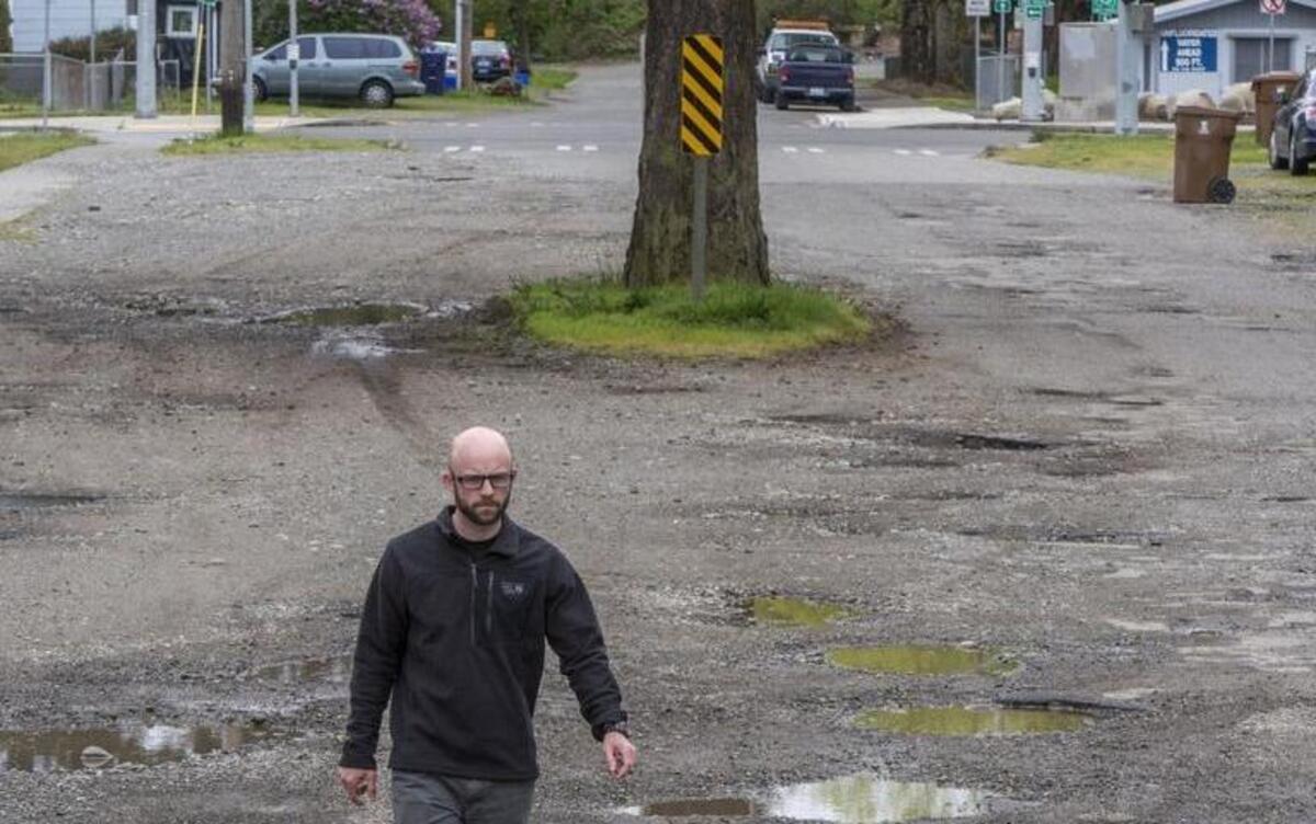 Chris Beale stands in the potholed, unpaved 7200 block of South Cedar Street near Arlington Elementary School. He filed an appeal on behalf of the South Tacoma Neighborhood Association over construction of a new school, citing what he terms an inadequate traffic study.