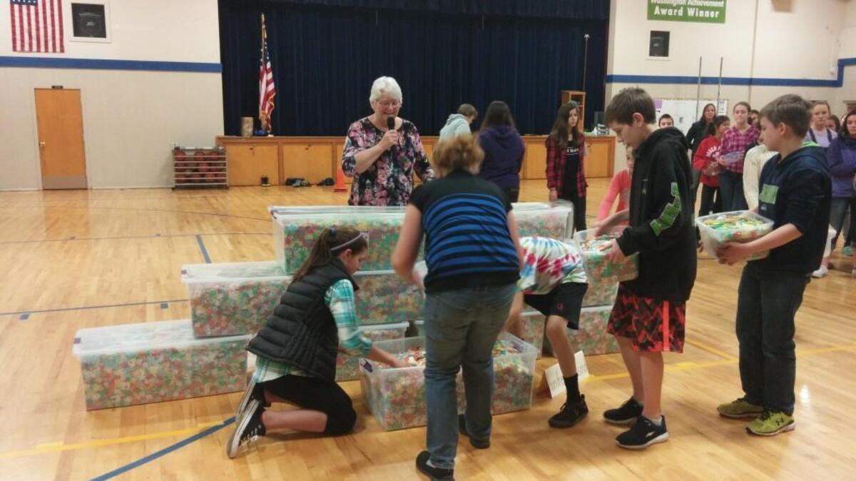 Teacher Kathy Johnstone directs students Thursday as they gather the final 100,000 bread tabs in their quest for 1 million of the plastic devices.