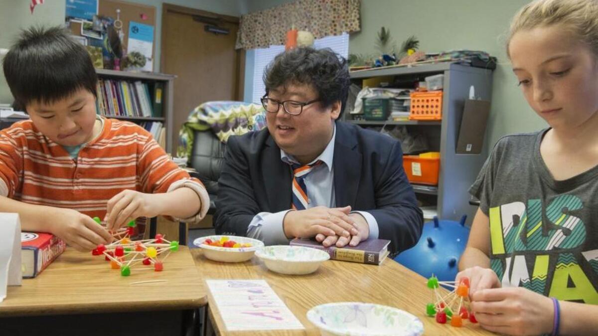 Korean educator Alex Im, center, works with Seabury fifth-graders Dylan Fong, left, and Anna Caplinger, to build a structure made of gumdrops and toothpicks that will support a heavy book.