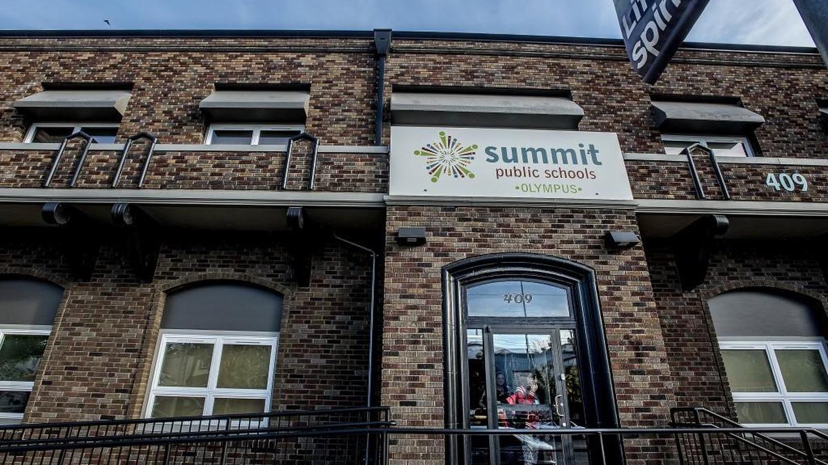 A student peers outside the front door Sept. 9 of Summit Olympus High School in Tacoma, one of three charter schools in Tacoma. All three schools are currently lobbying for the state to reallow them.