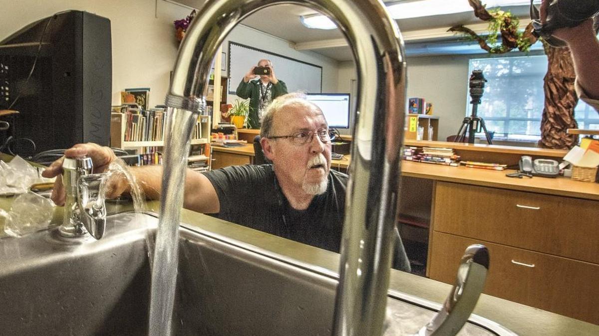 Frank Reil, a plumber with the Tacoma School District, tests the water Thursday after installing a new faucet and drinking fountain in the school library at Whittier Elementary.