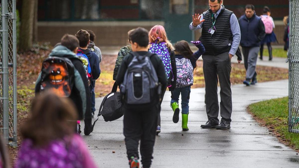 Manitou Park Elementary School, as part of a district-wide effort in Tacoma this year, has started sending “nudge letters” to parents of students missing too many classes. School principal Steven Mondragon greets students as they arrive on time Feb. 15.