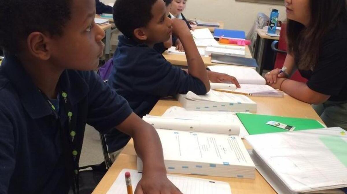 
Teacher Fredolyn Millendez works this week with students DaShawn VanCleave, foreground, and Dominic Navarro at Destiny Charter Middle School in Tacoma. 
