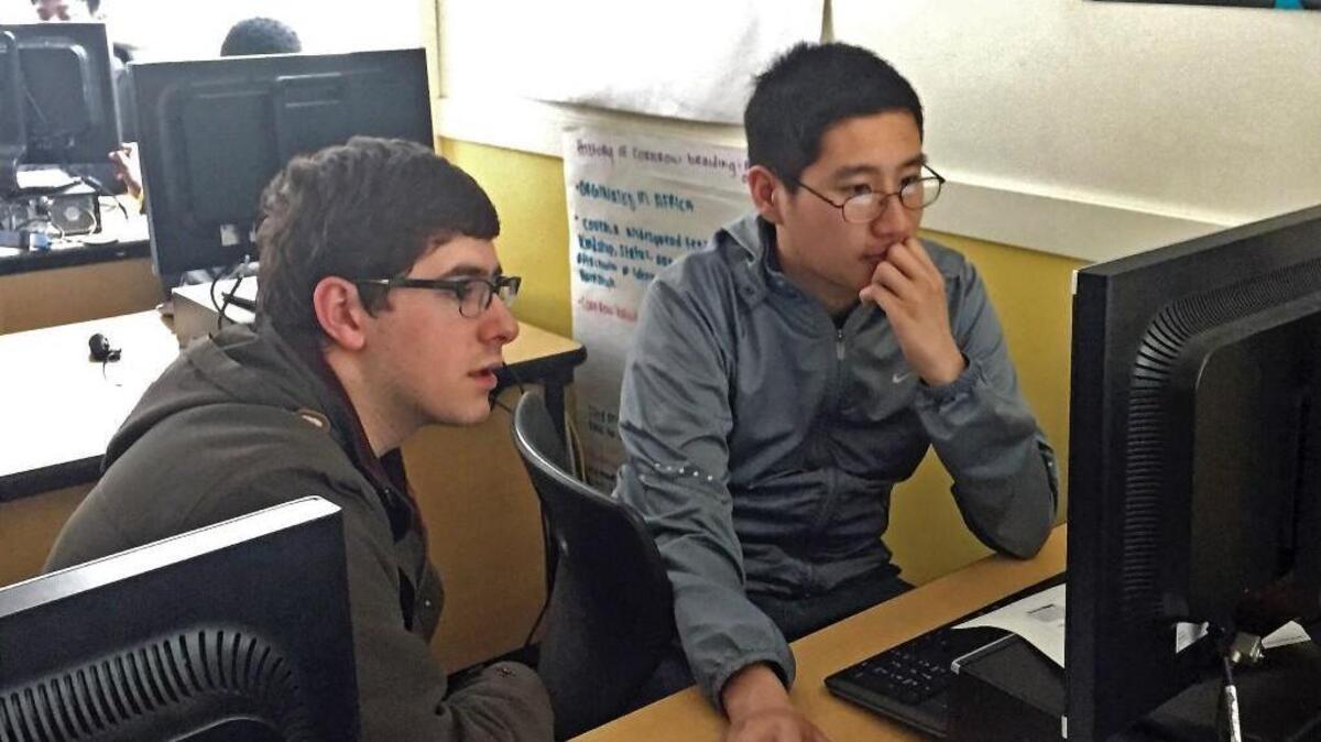UPS sophomore Jake Redman, left, assists Lincoln High student Antony Vo this month at Lincoln High School in Tacoma. Redman is part of Beta Coders, a group from the University of Puget Sound that tutors Lincoln students.