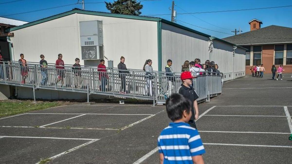Students walk in March 2015 from aging portable classrooms at Arlington Elementary School. The Tacoma School Board has awarded a bid to build the new Arlington Elementary School to Neeley Construction & Cabinet Co. of Puyallup.