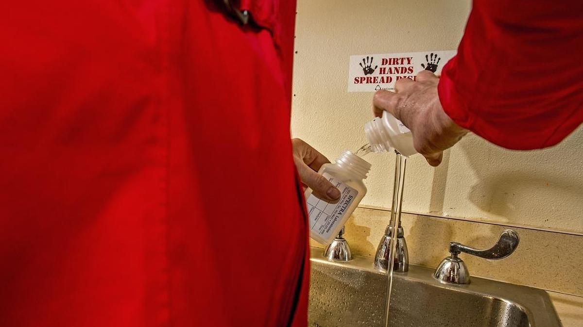 Donna McNeal, from Orion Environmental Services of Federal Way, collects water samples Tuesday from a faucet inside a classroom at Mann Elementary School in Tacoma.