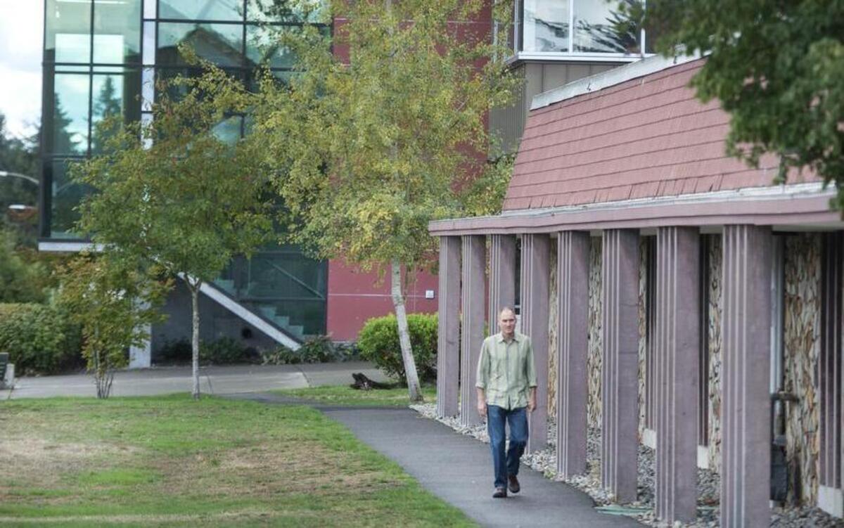 Professor Ralph Hitz walks on the Tacoma Community College campus, with the Pamela Transue Center for Science and Engineering in the background.
