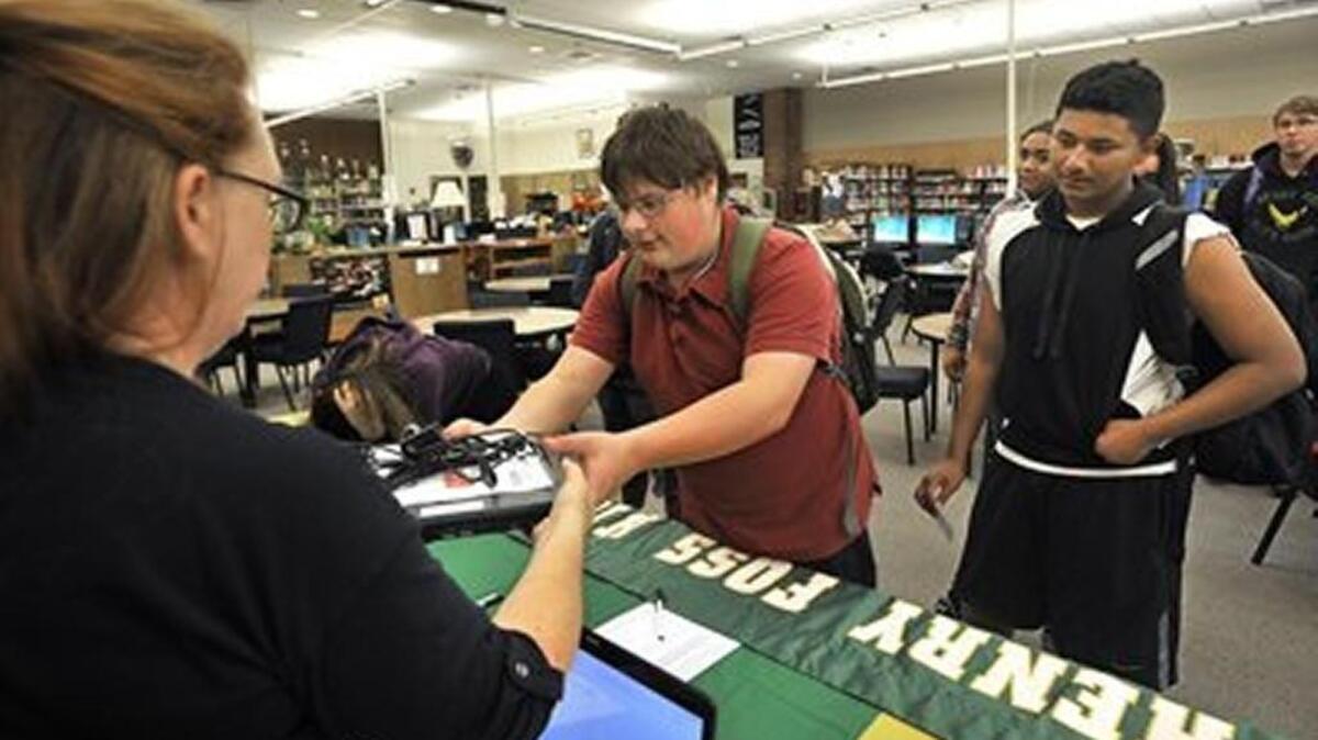 ​Foss High School students Justin Kiuorkas, left, and Jose Cruz Gonzalez-Helsham received refurbished laptops from the district in October.