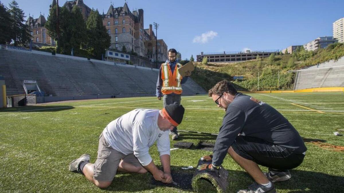 
Kevin and Connor Dorney of Sport Install West peel back a section of artificial turf at Stadium Bowl to do a tap test to determine if a targeted area was potentially hollow. Basel Kitmitto, background, of GeoEngineers, determined there was no evidence of a sinkhole. 
