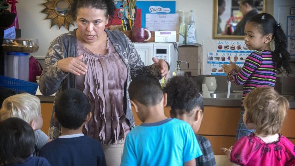 Assistant teacher Maria Leal-Guzman explains the importance of washing hands to her students at Willard Early Learning Center in Tacoma.