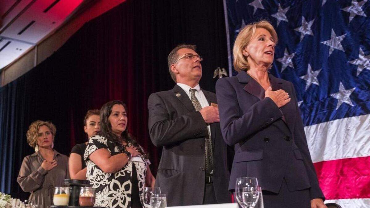Education Secretary Betsy DeVos stands for the National Anthem at the annual dinner of the Washington Policy Center Friday.