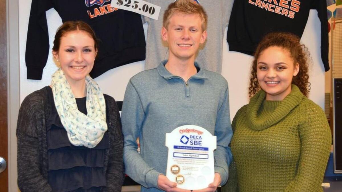 Lakes High School DECA students Siobhan Wells, from left, Ryan Habersetzer and Kadence Mitchell developed and submitted a report that earned gold-level re-certification for the school’s student store.