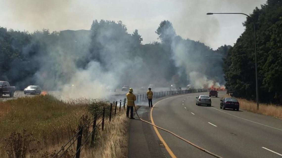 Central Pierce Fire & Rescue crews fight a brush fire in the median of state Route 512 in Puyallup on Saturday afternoon.