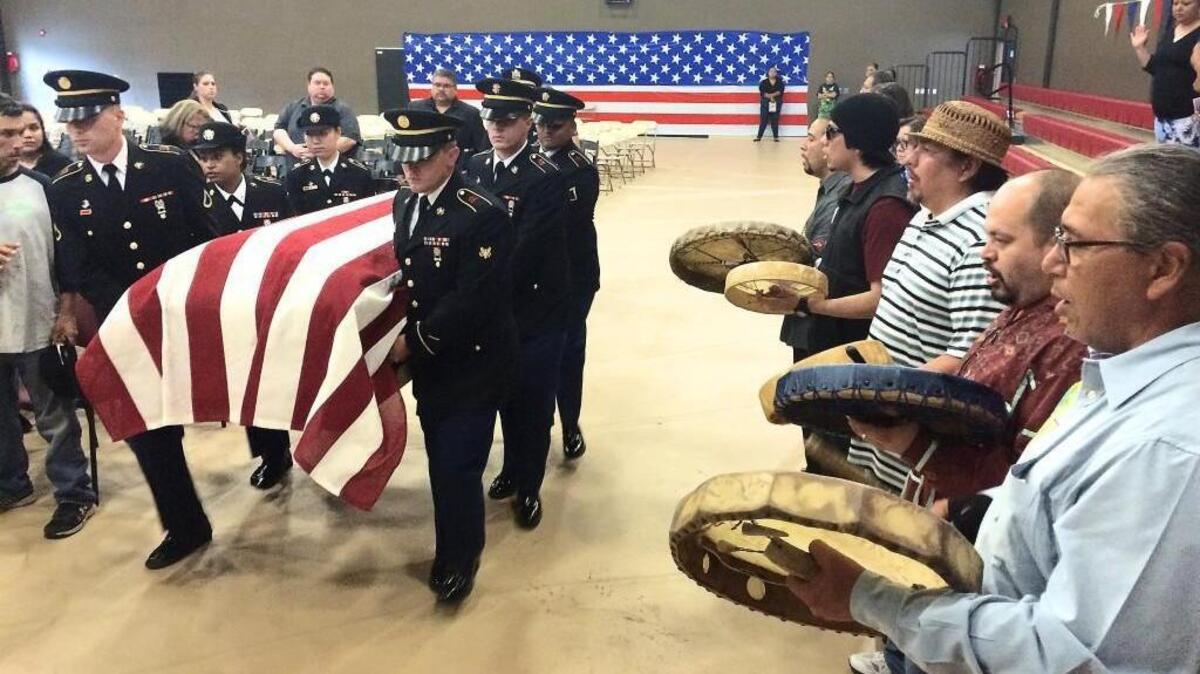 An Army honor detail bears the casket of First Lt. Leonard Reed Farron on Wednesday as drummers sing him out of the Puyallup Tribe Youth Center after his funeral. Farron was last seen Oct. 15, 1942, at the controls of a P-39 aircraft before he failed to return from a strafing mission over Tassafaronga, Guadalcanal. His remains were recently recovered and identified.