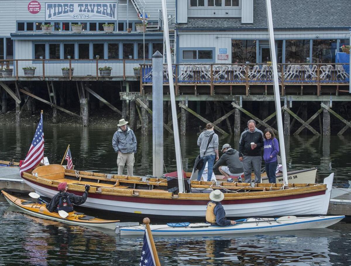 Wooden boat enthusiasts, maritime history buffs and curious kayakers surround The Porpoise, a replica of the longboat the Wilkes Expedition rowed into Gig Harbor in 1841, which was renovated for the 4th annual Classic Boat Show, hosted by the Tides Tavern. Reenactors rowed The Porpoise into the harbor in vintage naval uniforms to celebrate the 175th anniversary in 2016.
