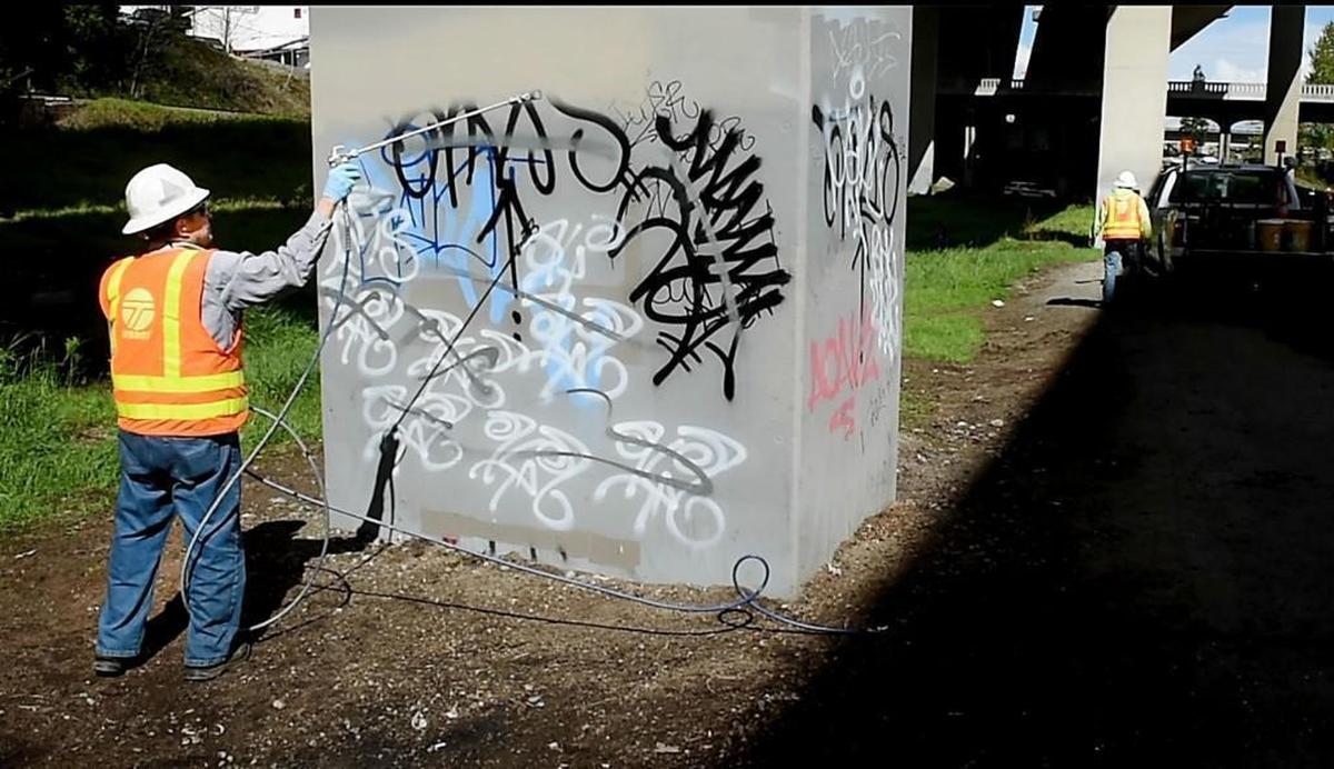 DOT worker John Spading paints over graffiti sprayed on a bridge pier underneath I-705 in Tacoma in 2017. Phase 2 of the city’s crime plan calls reducing visible disorder associated with crime, like graffiti and open drug use.