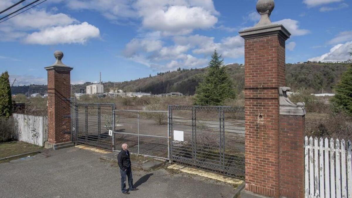 Citizen activist Noah Davis stands outside the front gate of the former Hooker Chemical Company on Alexander Avenue East this month. It is now owned by Occidental Chemical and still has heavy ground contamination.