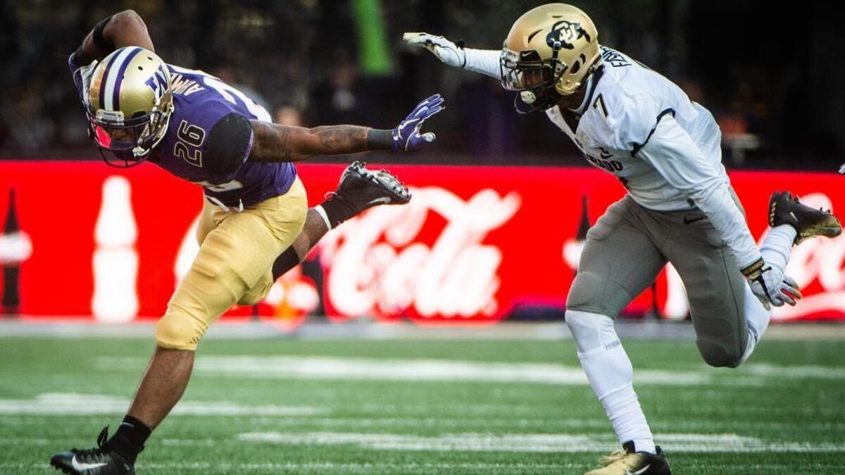 Washington running back Salvon Ahmed (26) tries to keep his balance as he rushes in the fourth quarter. The Washington Huskies played the Colorado Buffaloes in a NCAA football game at Husky Stadium in Seattle, Wash., on Saturday, Oct. 20, 2018.