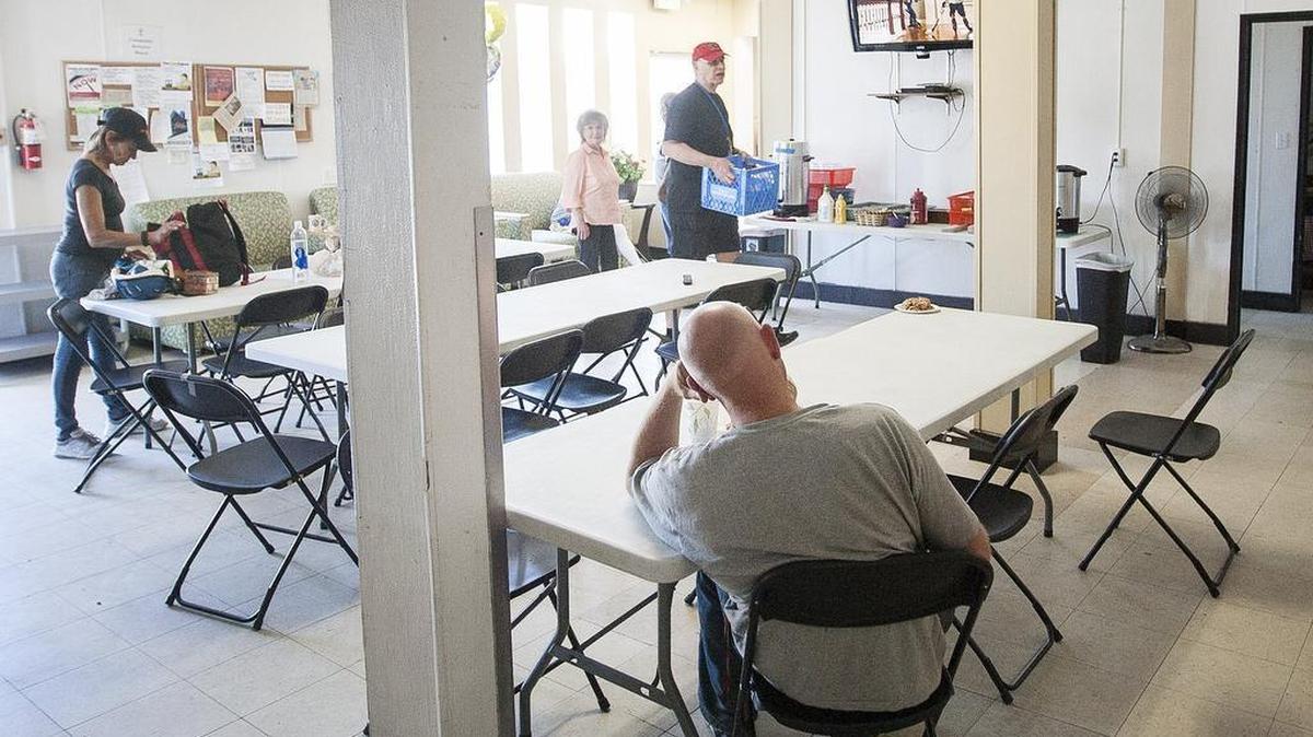 People sit and watch a movie inside the dining room of the New Hope Resource Center in Puyallup on June 3.