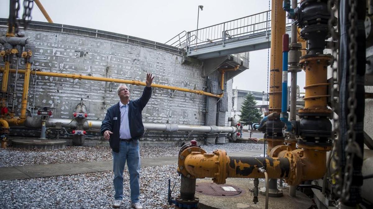 Operations supervisor Mike Patrick stands among the anaerobic digesters at the central wastewater treatment plant in Tacoma, Wash., on Thursday, Dec. 14, 2017. The anaerobic digesters produce methane gas which is moved via the orange lines to a holding tank and then used to heat buildings and water throughout the plant. Excess methane is burned off. The treatment plant wants to use the excess methane to produce renewable natural gas for use as transportation fuel.
