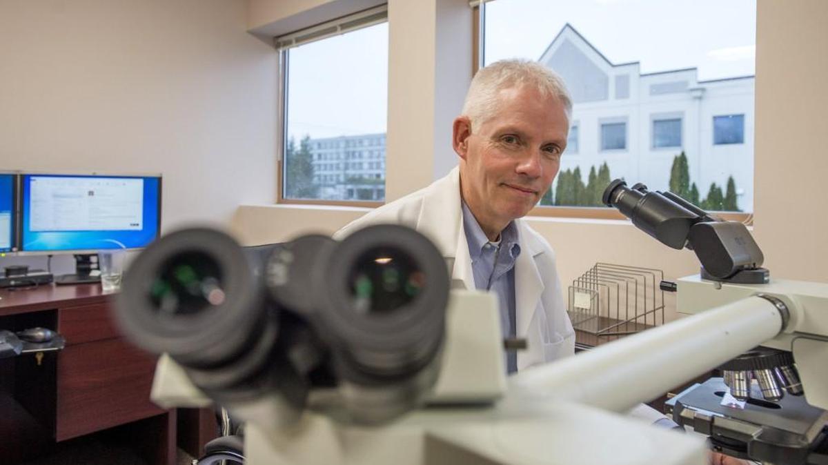 Dr. Thomas Clark, Pierce County chief medical examiner, is shown March 4, 2016 in his office with a teaching microscope.