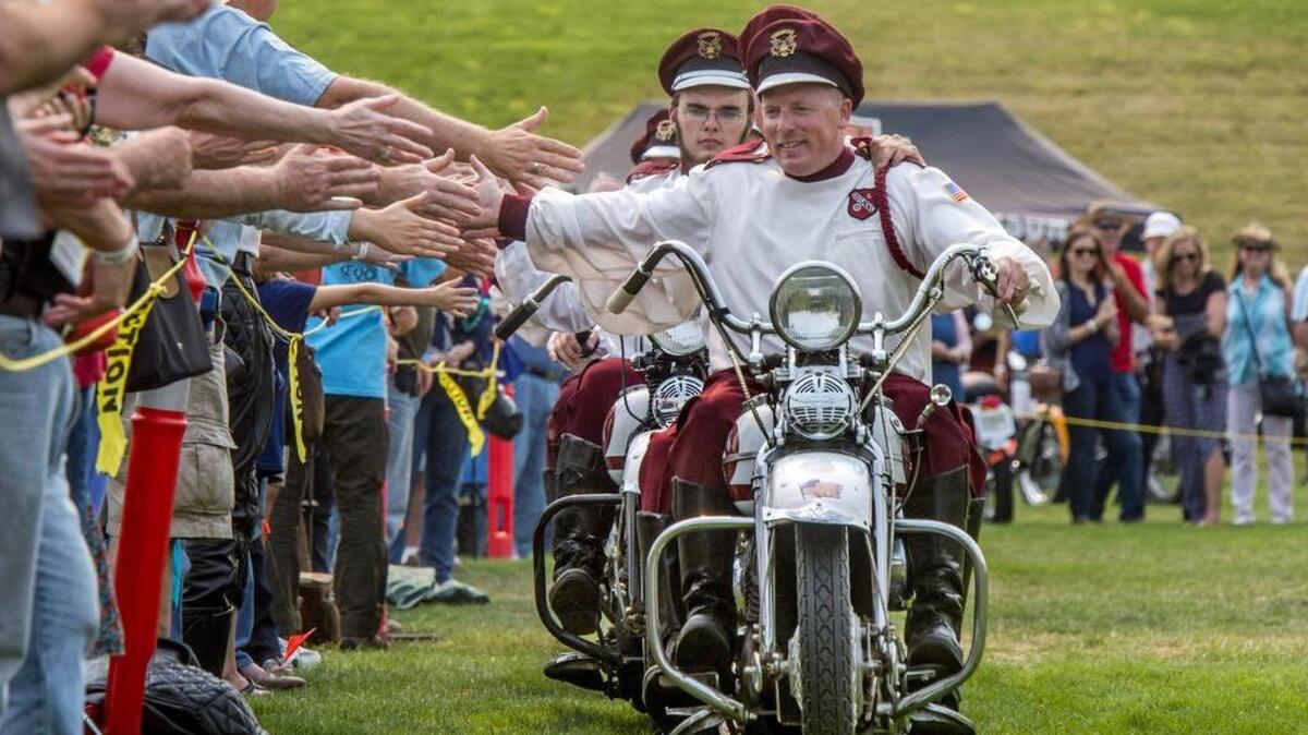 
The Seattle Cossacks Motorcycle Stunt and Drill Team end a performance by slapping hands with the audience at the fourth annual Vintage Motorcycle Festival at LeMay-America’s Car Museum in Tacoma on Saturday.
