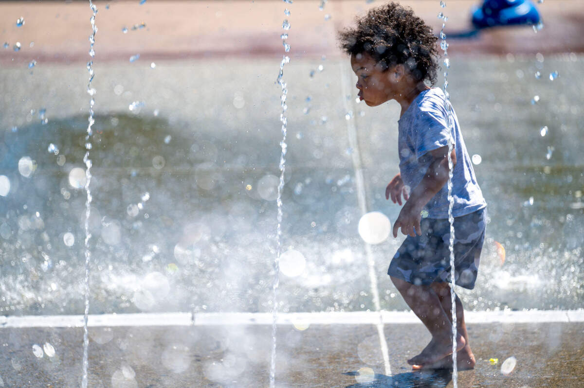 Khy’Shon Lopes, 2 of Tacoma, walks through an archway of water at the splash pad at Verlo Park in Tacoma on Tuesday, July 19, 2022.