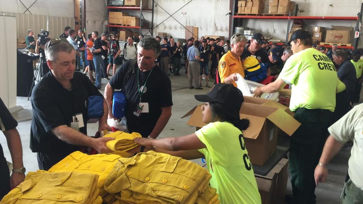 
Warren Heslip, 47, of Southland, New Zealand, receives a yellow firefighting shirt on Monday at the National Interagency Fire Center in Boise, Idaho. Australian and New Zealand firefighters have arrived in the United States and prepared to fan out to help fight wildfires burning in several western states.
