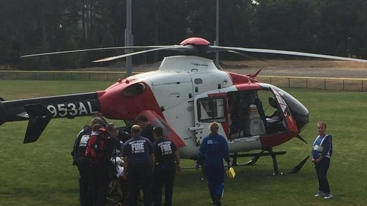 West Pierce Fire & Rescue medics load a woman with severe burns into a helicopter in University Place on Friday afternoon. She was flown to Harborview Medical Center in Seattle for treatment, West Pierce Assistant Chief Hallie McCurdy said.