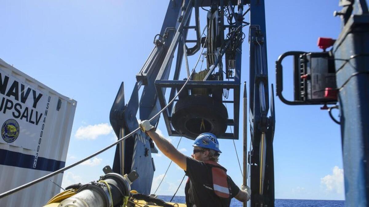 Tucker Bailey guides a towline through the A-frame while deploying the tow pinger aboard USNS Apache on Oct. 24. USNS Apache departed Norfolk, Va., on Oct. 19, to begin searching for wreckage from the missing cargo ship El Faro; the Navy ship is believed to have been found Saturday (Oct. 31) near where it was last reported.