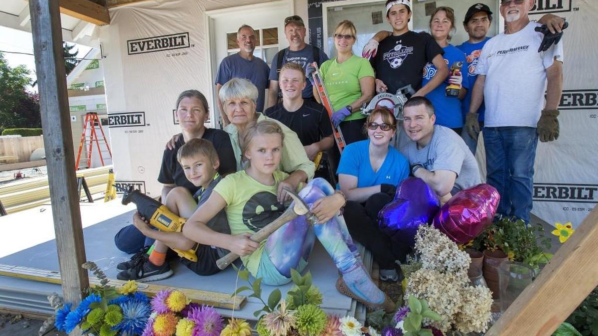 
Family, neighbors and friends pitched in over the weekend to help finish remodeling the rental property Richard Johnson was working on when he was tragically shot dead in Puyallup a month ago. At left is his widow, Sally, their daughter Julie Miller (in black), and Julie’s children Mackenzie (with hammer), Kyle and Gavin (also in black). 
