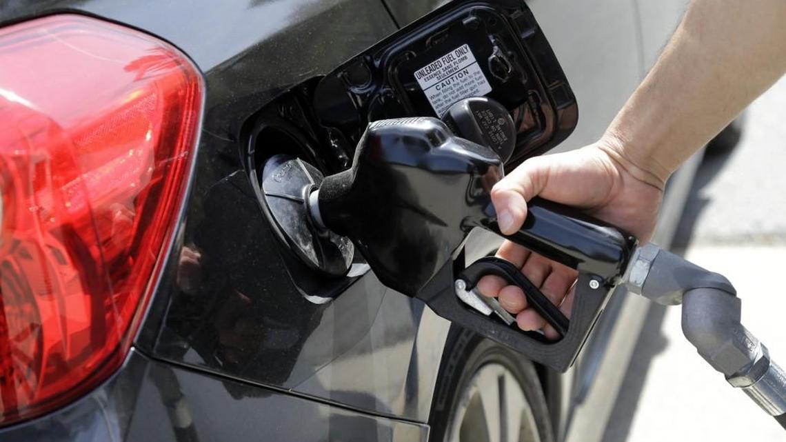 In this 2015 photo, gas station attendant Carlos Macar pumps gas in Andover, Mass. Drivers in Washington soon will see stickers at the pumps announcing the state’s 67.8 cents per gallon gas tax, the nation’s second highest.