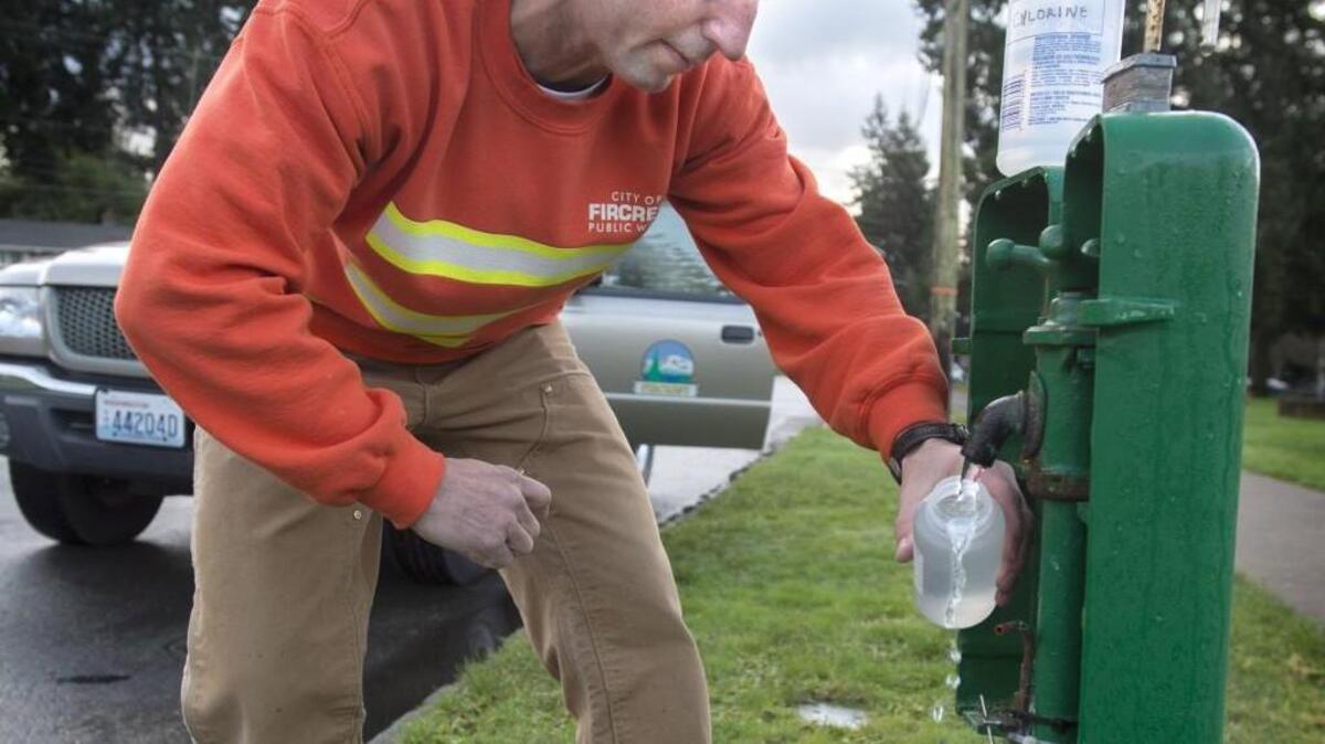 Fircrest Public Works employee Tim Piercy collects a monthly water sample Wednesday from one of seven sample collection stations by Fircrest Park in Fircrest. The city has to add chlorine to its water after it had four hits of coliform in the tests over a 12-month. The total coliform is not a major public health risk, but the tests mean there is a potential for more serious bacteria to enter the water source.