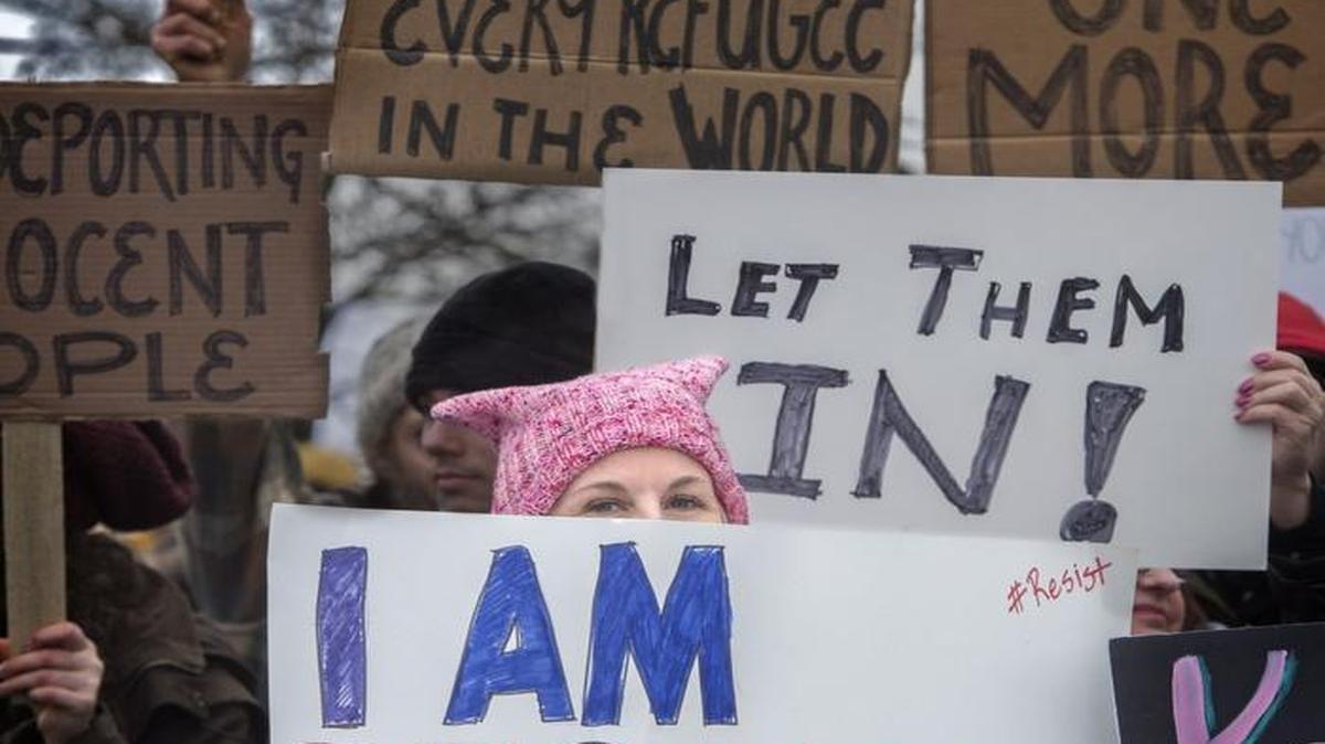 Loraine Hirakawa of Puyallup, center, holds a sign during a protest Sunday at the Northwest Detention Center in Tacoma.