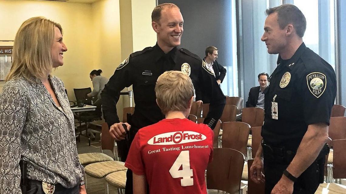 Detective Micah Wilson, center, of the Puyallup Police Department, talks to other attendees at the ceremony where he was awarded the Washington State Law Enforcement Medal of Honor on Wednesday.