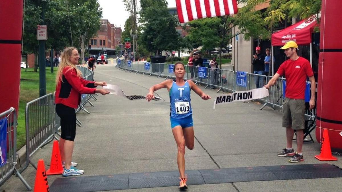 Kate Landau breaks the tape at Tollefson Plaza to win the Tacoma Narrows Half Marathon in 2016.