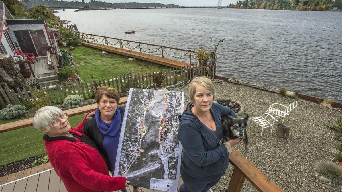 Neighbors Heather McFarlane, from left, Marti Snyder-Gray and Karen Miller oppose Taylor Shellfish’s plan for a 25.5-acre geoduck farm in Burley Lagoon. Miller, holding her dog Zoey at her waterfront home Friday, says Taylor Shellfish’s clam and oyster operations have infringed on her privacy by making noise and shining boat work lights through her windows at night. Miller shares McFarlane’s and Snyder-Gray’s concerns over safety and environmental issues of what would be, if approved, the largest geoduck operation in Pierce County. The three woman are members of the group Friends of Burley Lagoon and are holding a photo/map of the lagoon near Purdy.