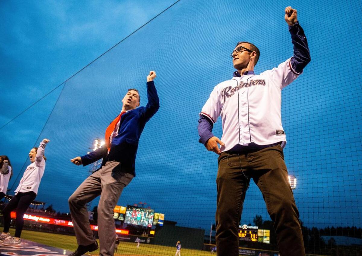 Columnist Matt Driscoll dances on the third base dugout with Casey Catherwood, creative director with the Tacoma Rainiers, and the Rainier Fun Squad, during the seventh inning stretch of the Tacoma Rainiers’ game against the Las Vegas 51s at Cheney Stadium in Tacoma, Wash., on Thursday, June 28, 2018.