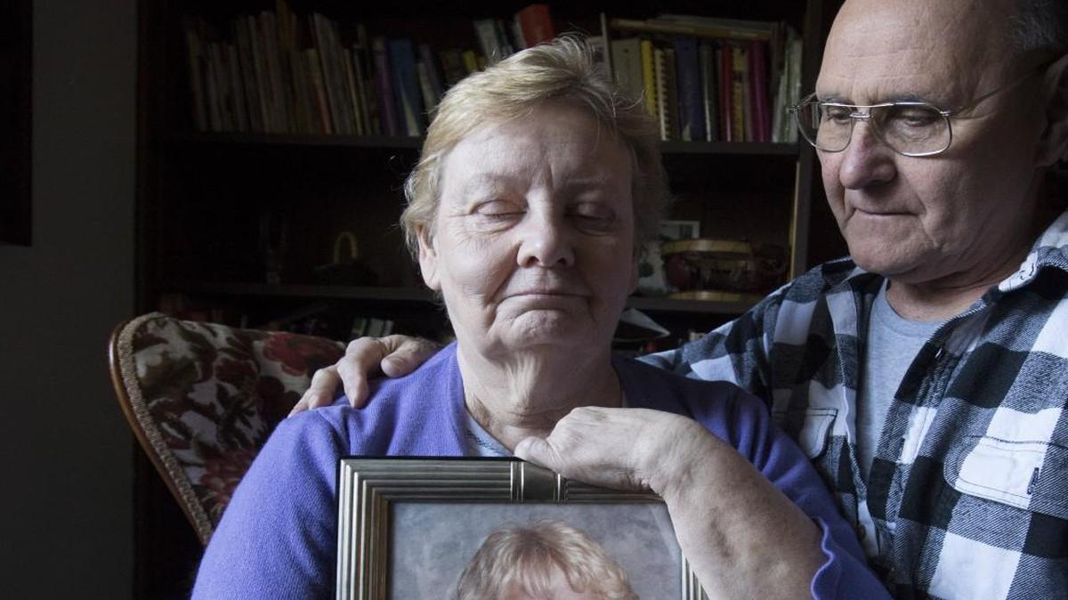 Nona Smith holds a picture of her son Matthew while her husband, Ben, lends support at their Bonney Lake home on Thursday, March 17. Matthew died in October while at the Pierce County Jail.