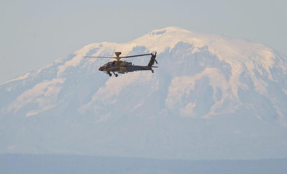 An Apache attack helicopter files over the Yakima Training Center during an air-to-ground missile exercise, September 10, 2013. Mt. Adams is in the background.