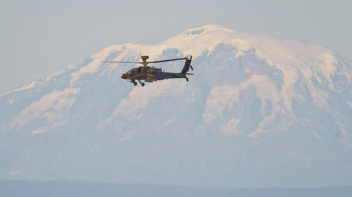 An Apache attack helicopter files over the Yakima Training Center during an air-to-ground missile exercise at the Yakima Training Center in September 2013. Mount Adams is in the background.