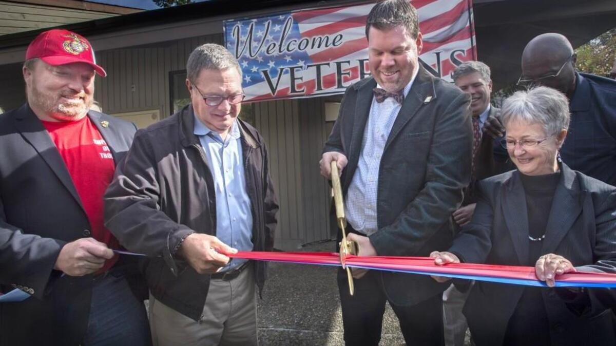 U.S. Congressman Denny Heck, center left, helps Lacey Mayor Andy Ryder cut the ribbon for the Lacey Veterans Services Hub grand opening in Lacey on Friday.